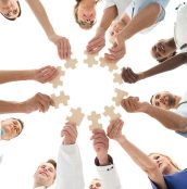 Directly below shot of medical team joining jigsaw pieces in huddle against white background